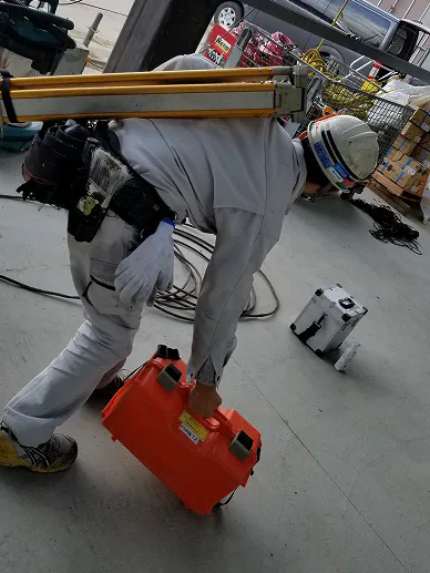 現場で機材を運ぶ社員